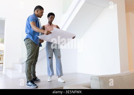 Examen des plans divers couple portant des vêtements décontractés dans le hall moderne, espace de copie Banque D'Images