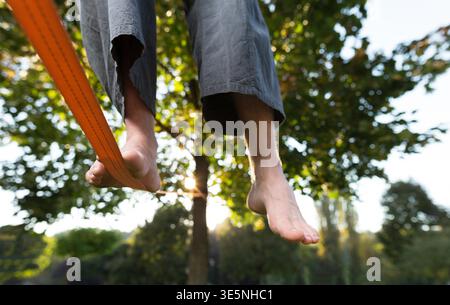 Gros plan du mans pieds balance une corde raide ou en environnement parc slackline avec un pied au-dessus de la corde. Banque D'Images