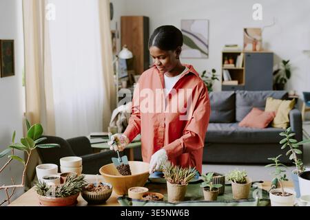 Femme adulte noire repotting plantes d'intérieur pour Home Lifestyle Content Banque D'Images