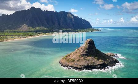 Vue aérienne de l'emblématique îlot conique de Mokolii s'élevant des eaux turquoises avec pour toile de fond la majestueuse chaîne de montagnes Ko'olau, Banque D'Images
