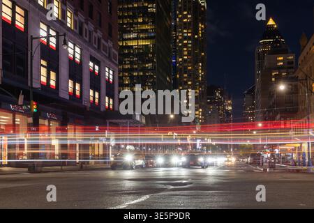 New York City, New York, États-Unis - 24 avril 2024 : rues nocturnes de Manhattan avec de longues traînées de lumière des voitures qui passent et de la circulation urbaine active Banque D'Images