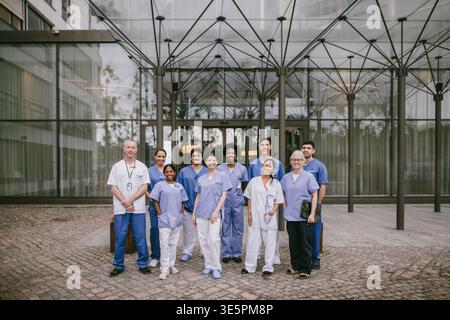 Portrait de groupe de professionnels de la santé masculins et féminins debout à l'extérieur du bâtiment de l'hôpital Banque D'Images