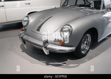 Une vue rapprochée de la face avant d'une Porsche 356 argentée classique des années 1950 avec des phares arrondis, un pare-chocs chromé et une poignée de capot distinctive. Banque D'Images