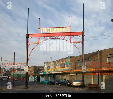 L'arche du marché Barras et la tour d'enseigne peinte au-dessus d'une rue calme de devantures fermées, peintures murales et voitures garées, évoquant l'histoire du marché urbain, local c Banque D'Images