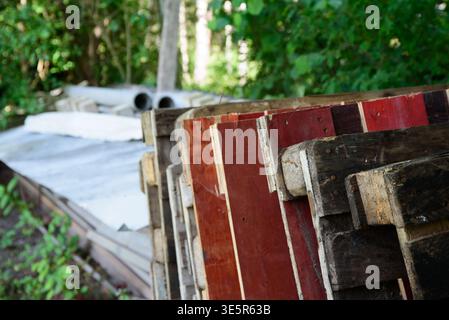 palettes en bois placées près de la clôture par une journée ensoleillée en été Banque D'Images