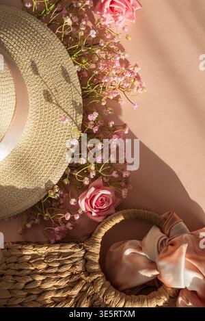 Chapeaux de paille, sac à main et fleurs. Élégant printemps été Fashion Flatl ay sur fond rose Banque D'Images