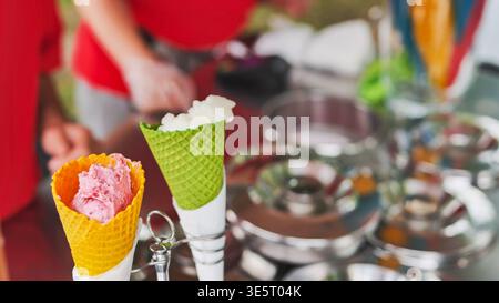 Cônes de gaufre colorés avec différents sorbets aromatisés lors d'une chaude journée d'été Banque D'Images