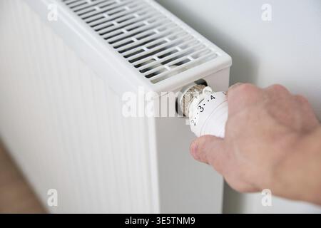 Régler manuellement la température sur le thermostat du radiateur de chauffage, tourner le bouton du radiateur de chauffage pour contrôler la chaleur dans la maison Banque D'Images