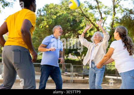 De vieilles multinationales jouent au volley-ball sur une aire de jeux d'été pour les sports au printemps dehors Banque D'Images