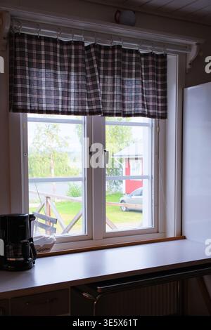 Jakkvik, Suède - 28 juillet 2024 : une vue paisible de l'intérieur de l'hébergement STF Jakkvik montrant les collines herbeuses environnantes et les bâtiments ruraux th Banque D'Images