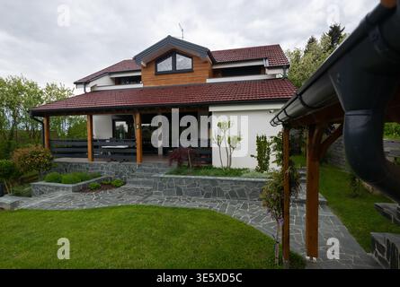 Maison familiale moderne de deux étages avec porche couvert, patio en pierre et jardin paysager Banque D'Images