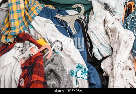 Grande pile de vêtements colorés en désordre dispersés sur le sol, journée de blanchisserie et concept de tâches ménagères. Banque D'Images