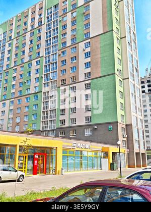 Orenburg, Russie - 22 août 2025 : des clients sont vus entrer et sortir du magasin Magnit alors que les voitures sont garées à l'extérieur dans un environnement urbain animé. Banque D'Images