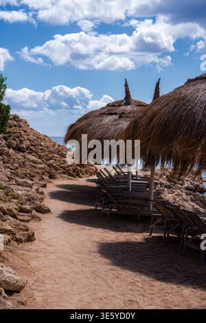 Sentier côtier de Sharm el Sheikh avec palapas et chaises longues Banque D'Images