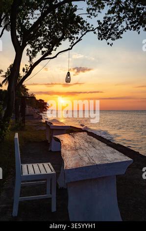 Table et chaise au bord de la mer, Bali, Indonésie, Asie du Sud-est. Table et chaise pour la détente au coucher du soleil, Bali, Indonésie. Banque D'Images