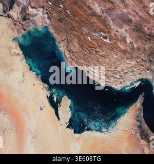 Vue de dessus satellite du golfe Persique, mettant en valeur le contraste entre les eaux bleues profondes, les chaînes de montagnes brunes accidentées de l'Iran et la vaste sa dorée Banque D'Images