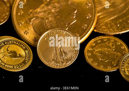 Winneconne, WI - 28 mars 2026 : une collection de pièces d'or représentant une pièce d'or d'aigle américain en or sur un fond isolé. Banque D'Images