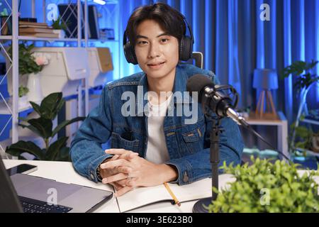 Homme enregistrant un podcast dans une configuration studio professionnelle. Participer à une session de streaming en direct avec microphone et casque. Concept de podcasting et onlin Banque D'Images