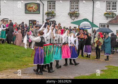 The Cuckoo's Nest, un groupe féminin de danseuses Morris se produit sous la pluie lors d'un vendredi Saint humide devant le pub Tiger, East Dean, East Sussex. Banque D'Images