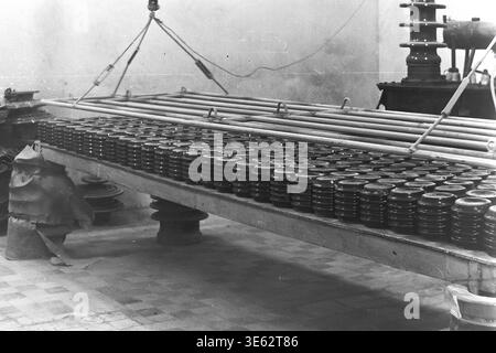 Slavyansk, années 1970, usine d'armature-isolant. Les isolateurs en céramique finis OFR-750 sont disposés en rangées nettes sur une longue table de production industrielle. Le processus technologique de séchage ou de refroidissement des produits à l'intérieur de l'atelier d'entreprise. L'atmosphère industrielle d'une grande usine soviétique, démontrant l'ampleur impressionnante de la fabrication d'équipements électriques. Une authentique photographie d'archives historiques véhiculant l'esprit du travail créatif, la vie quotidienne industrielle soviétique, les jours de travail de routine de l'époque, et le Donbass paisible. Banque D'Images