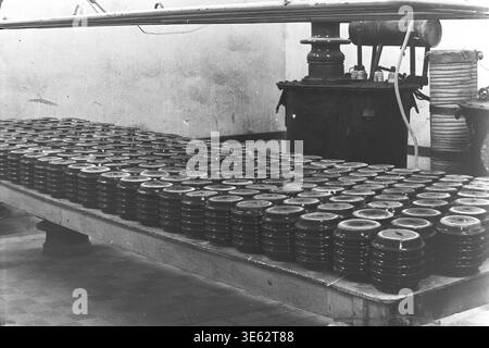 Slavyansk, années 1970, usine d'armature-isolant. Les isolateurs en céramique finis OFR-750 sont disposés en rangées nettes sur une longue table de production industrielle. Le processus technologique de séchage ou de refroidissement des produits à l'intérieur de l'atelier d'entreprise. L'atmosphère industrielle d'une grande usine soviétique, démontrant l'ampleur impressionnante de la fabrication d'équipements électriques. Une authentique photographie d'archives historiques véhiculant l'esprit du travail créatif, la vie quotidienne industrielle soviétique, les jours de travail de routine de l'époque, et le Donbass paisible. Banque D'Images