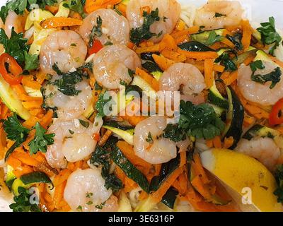 Vue rapprochée du ciel d'un plat de pâtes de crevettes et légumes préparé. La composition comprend de multiples crevettes cuites roses dispersées sur A. Banque D'Images