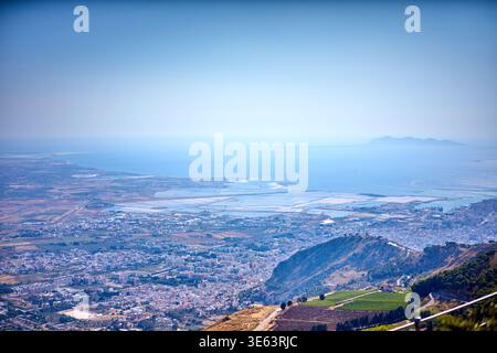 Une vue aérienne panoramique depuis un point de vue élevé surplombant la ville côtière de Trapani en Sicile, en Italie. Le premier plan présente des collines ondulantes Banque D'Images