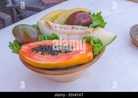 Assortiment de fruits tropicaux avec melon de papaye, bananes mangue et laitue sur assiette vue de dessus composition Banque D'Images