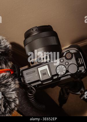 Vue de dessus d'un appareil photo Canon EOS R50 sans miroir avec objectif RF-S et microphone externe fuzzy Deadcat monté sur un trépied Banque D'Images