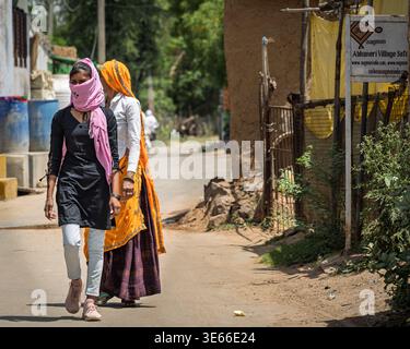 Village d'Abhaneri, Rajasthan, Inde--13 avril 2023. Deux femmes marchent le long d'une route rurale dans le village d'Abhaneri, Rajasthan, Inde. On porte un o traditionnel Banque D'Images