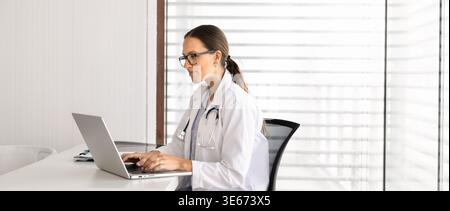 Bannière de femme médecin travaillant sur ordinateur portable dans le bureau de la clinique Banque D'Images