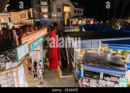 Escalier roulant extérieur illuminé et escaliers rouges la nuit à Sanya Banque D'Images