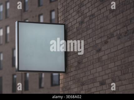 Un signe blanc blanc carré minimaliste vide monté sur Une façade en brique moderne pour votre texte Banque D'Images