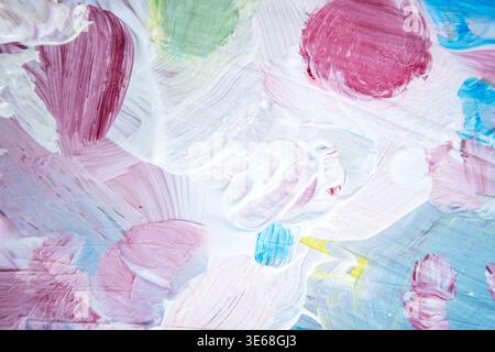 Œuvre d'art abstraite mettant en vedette des tourbillons colorés de peinture rose, bleue, verte et jaune sur une surface blanche texturée, créant une composition visuellement attrayante Banque D'Images