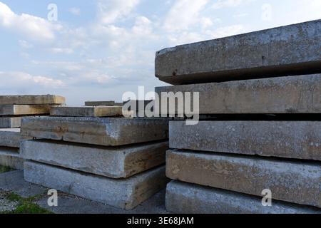 Un grand plan extérieur de plusieurs piles soignées de dalles en béton armé ou de panneaux préfabriqués. L'image affiche la texture grise rugueuse Banque D'Images