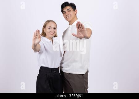 Jeune couple montrant un geste d'arrêt avec les mains en avant Banque D'Images