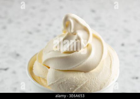 Un gros plan de crème glacée molle à la vanille dans une tasse. Banque D'Images