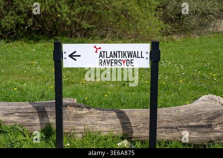 Ostende, Belgique - 14 avril 24 : panneau directionnel blanc pointant vers le site patrimonial Atlantikwall Raversyde sur la côte belge. Banque D'Images