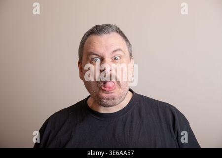 L'homme mûr regarde avec un regard étonné, les lèvres floues Banque D'Images