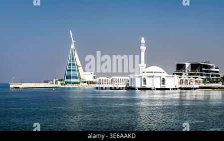 Djeddah, Arabie Saoudite - 11 février 2026 : la mosquée Al Rahmah et le bâtiment moderne du Jeddah Yacht Club se dressent sur la côte de la mer Rouge pendant un clair Banque D'Images