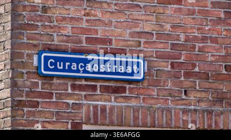 Vue détaillée d'un panneau de rue bleu sur un mur de briques rouges avec le nom Curaçaostraat, situé à Urk, pays-Bas Banque D'Images