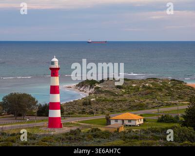 Geraldton, Australie occidentale, Australie – 17 août 2025 : une vue de drone montre le phare de point Moore avec un cargo à l'horizon. Banque D'Images
