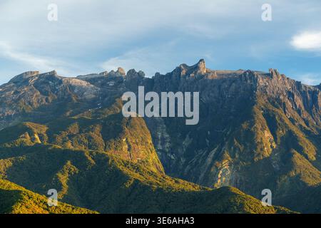 Mont Kinabalu, Sabah, Malaisie – 21 septembre 2025 : une vue téléphoto montre des falaises ensoleillées, des crêtes rocheuses et des pentes boisées sur le Mont Kinabalu. Banque D'Images