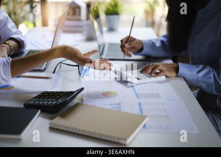 Pour l'enquête sur un compte de corruption, un groupe de femmes d'affaires et de comptables recherchent des documents de données sur un ordinateur portable. Définition de la lutte contre la corruption Banque D'Images