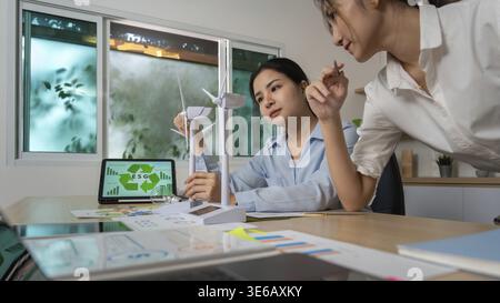 Deux femmes d’affaires collaborent sur des projets ESG, analysant des données et discutant de solutions durables dans un bureau moderne Banque D'Images
