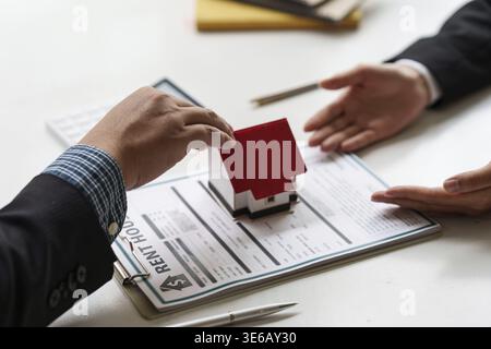 Fermez homme d'affaires ou agent donnant la maison après avoir signé l'accord pour acheter la maison. Directeur de banque et concept immobilier Banque D'Images