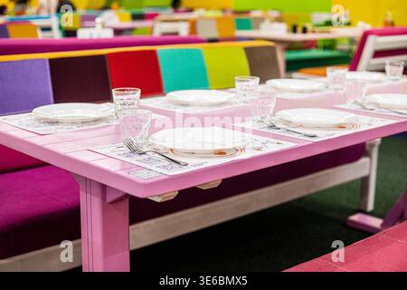 Un ensemble de table rose pour une fête d'anniversaire dans un centre commercial et de divertissement pour enfants. Banque D'Images