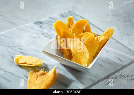 Une vue d'un bol de tranches de mangue séchées. Banque D'Images