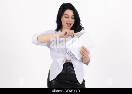 Jeune femme en chemise blanche déchirant une carte bancaire en deux Banque D'Images