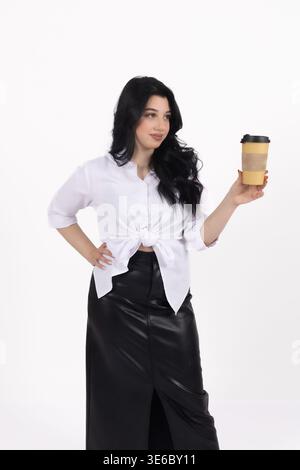 Femme élégante en chemise blanche tenant une tasse de café à emporter Banque D'Images